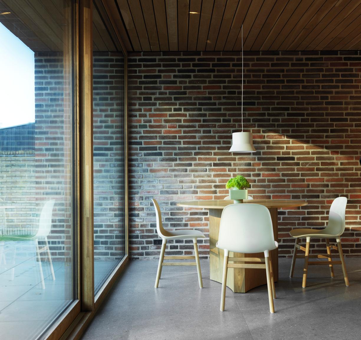 A chair of forms warm gray with a black oak base