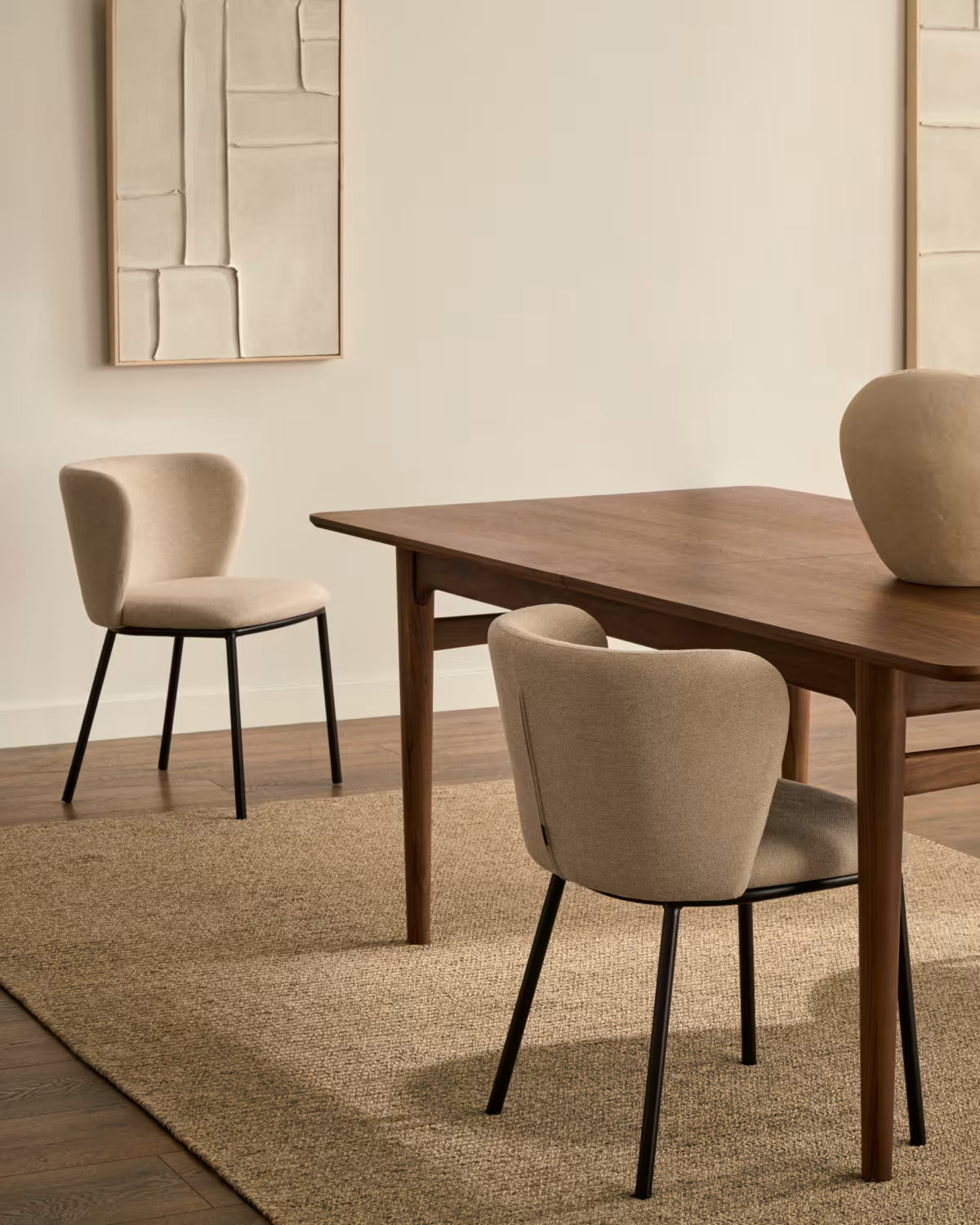 Ein Stuhl im Ciselia Beige Szenil Stoff mit einer schwarzen Basis
