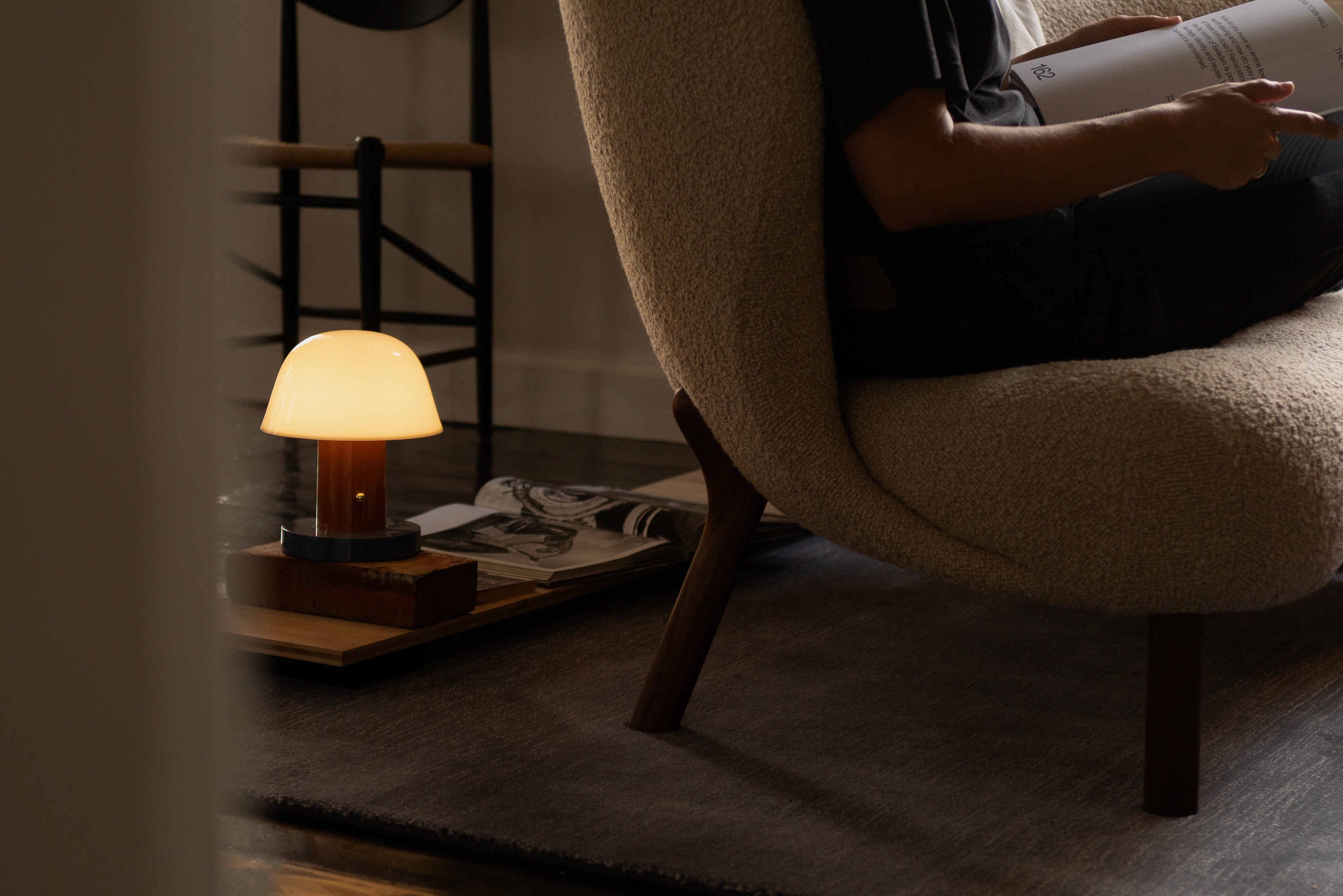 Tragbare Lampe SETAGO JH27 mit cremefarbenem Schirm und orange-blauem Fuß.