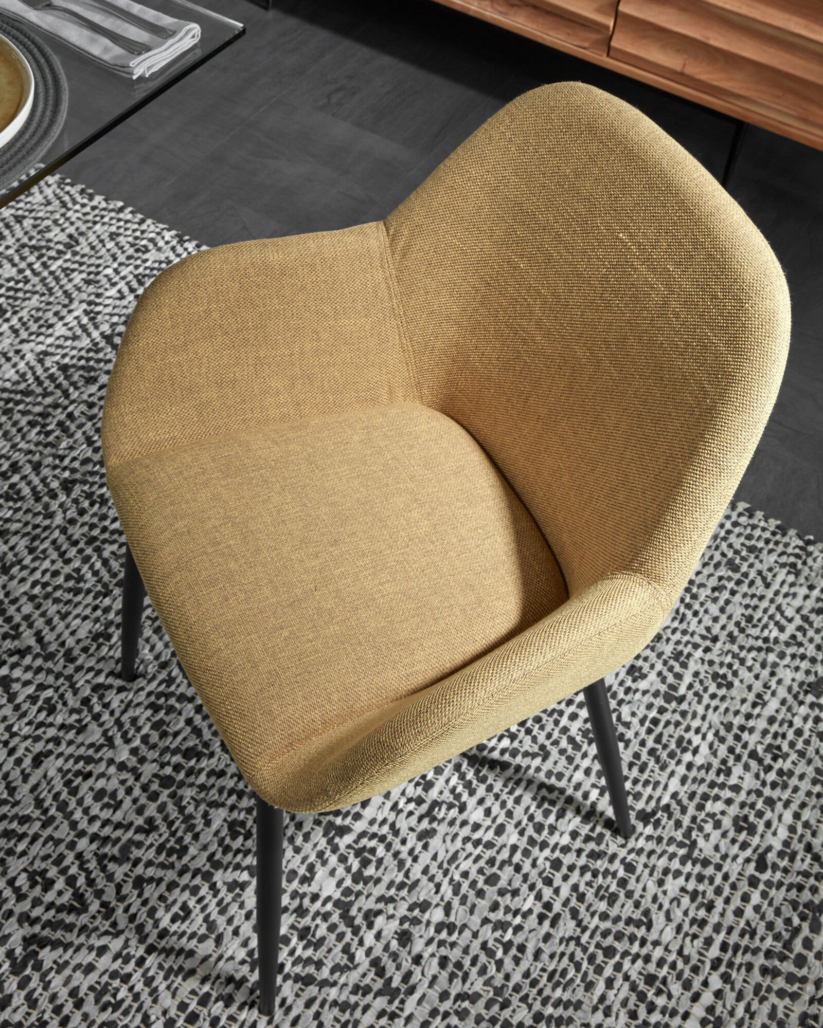 A chair in a black mustard horse fabric with a black base