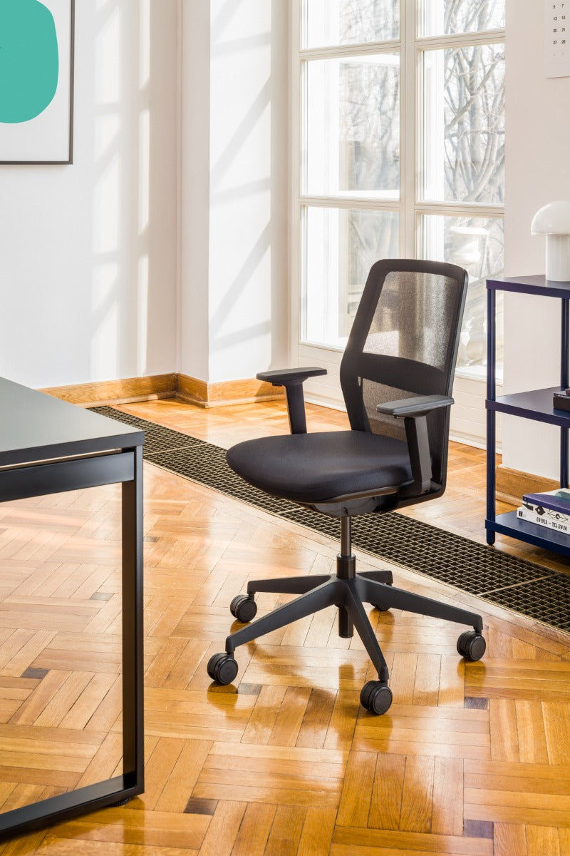 Sessel mit einer offenen Rückenlehne mit offener Arbeit mit Rädern an der harten Oberfläche