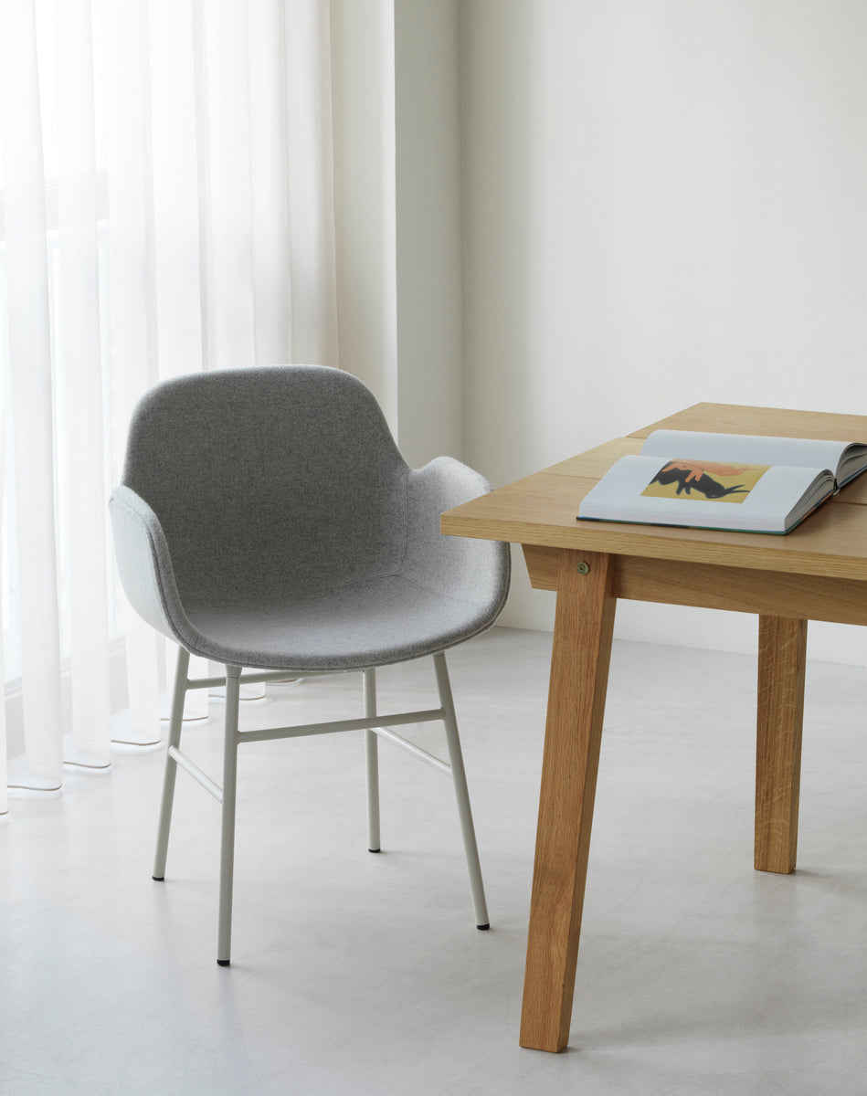 A chair upholstered with armrests of forms with a black base