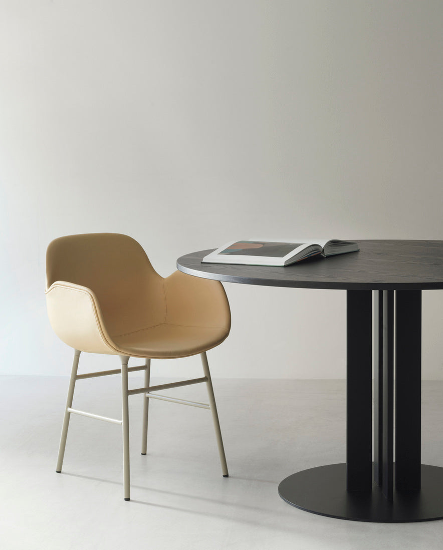 A chair upholstered with armrests of forms with a black base