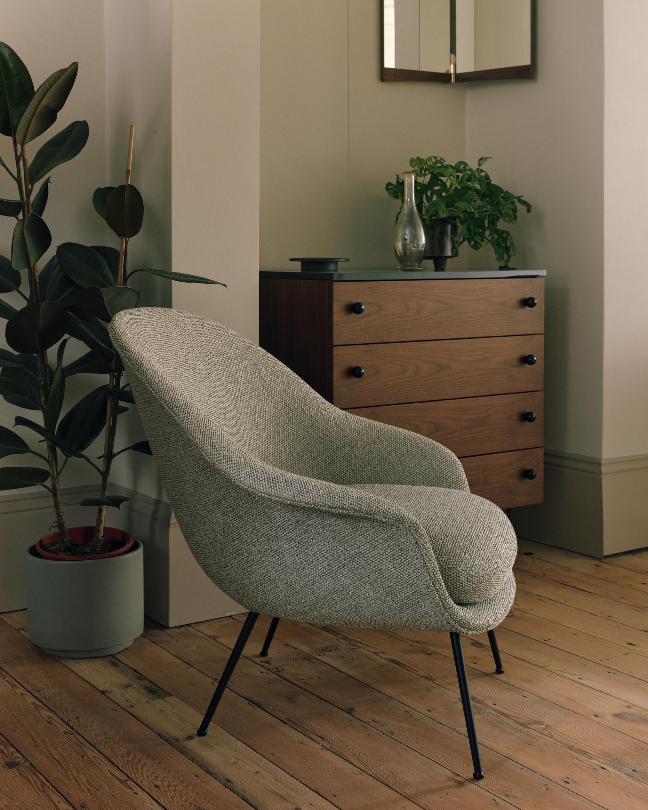 Upholstered BAT armchair with a gold base