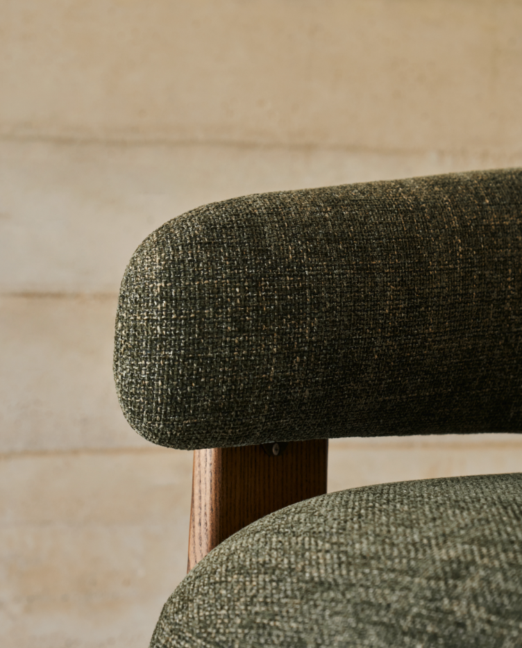 Green green armchair with a dark wooden base