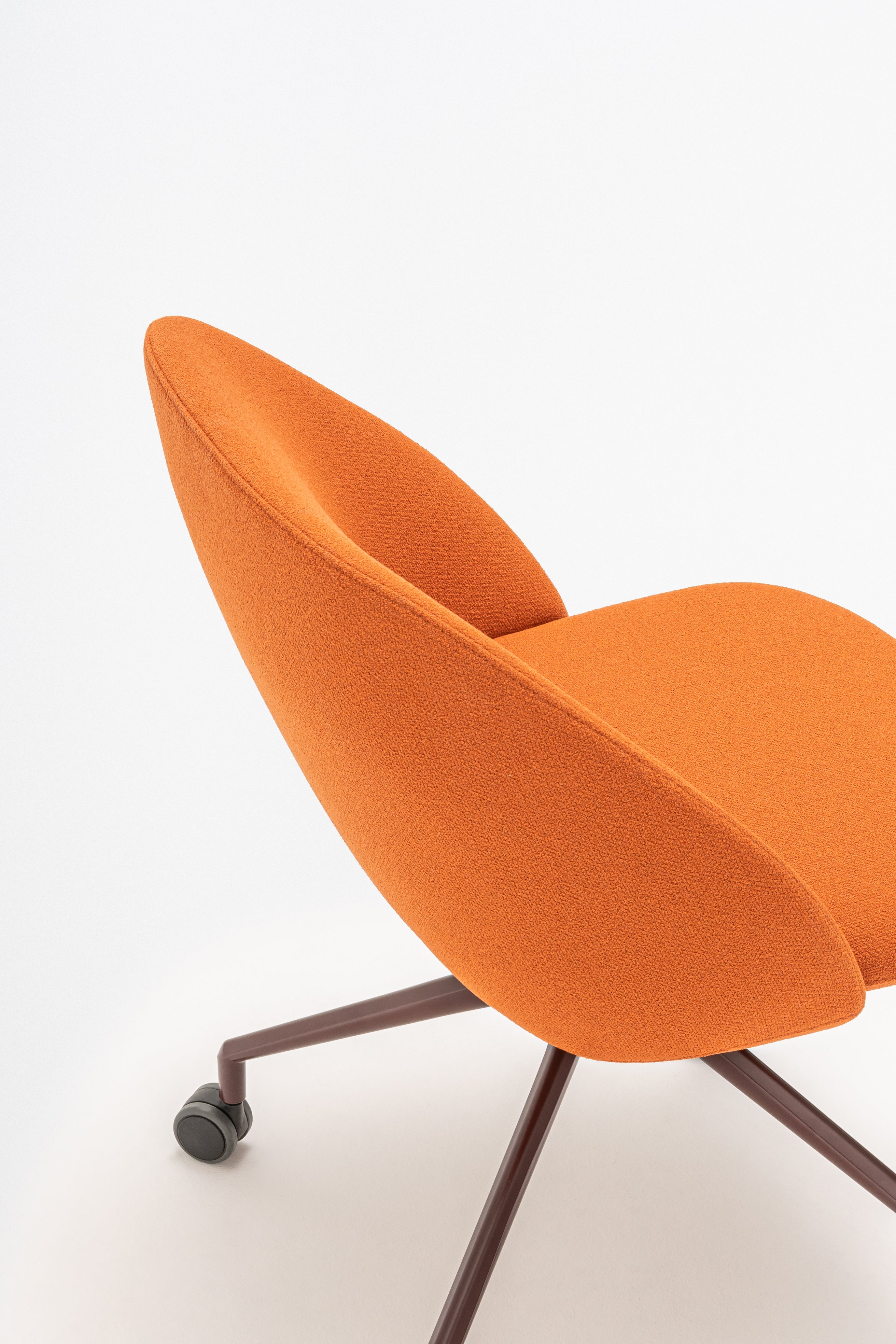 Rotable armchair with low backrest metal parallel base with wheels to a soft surface