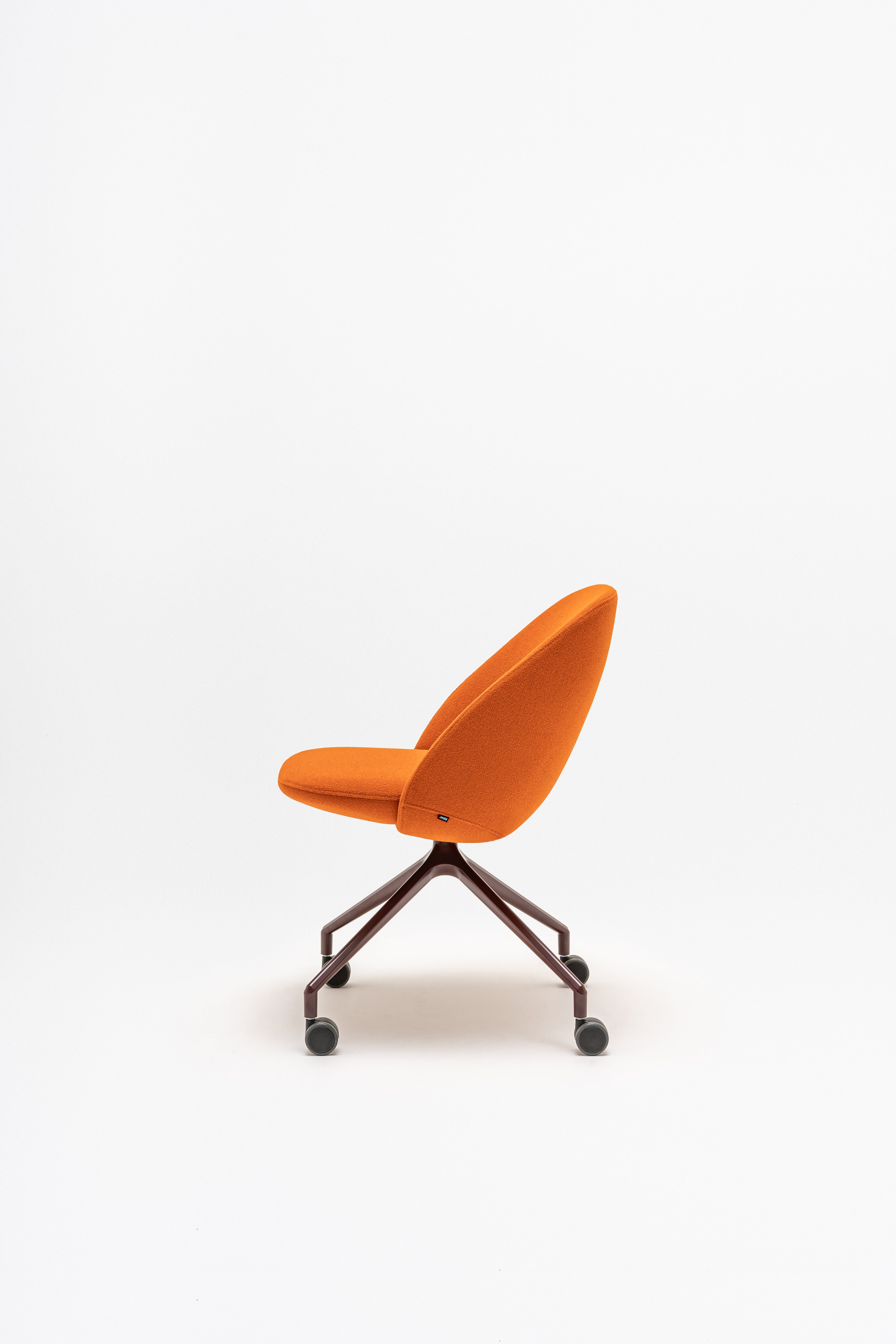 Rotable armchair with low backrest metal parallel base with wheels to a soft surface