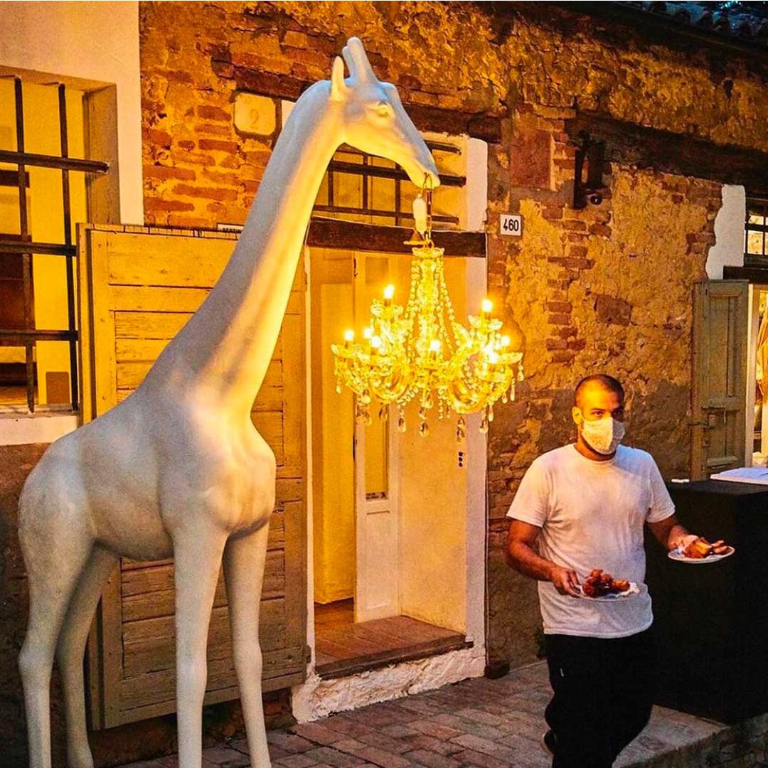 Designed by Marcantonio, Giraffe in Love M is a giraffe with a height of 2.65 meters, which holds a classic Marie-Thérèse style chandelier, completely waterproof and having an IP65 certificate. Brave and elegant, naturally will be in the center of attention of every space in which it will be found, both inside and outside.