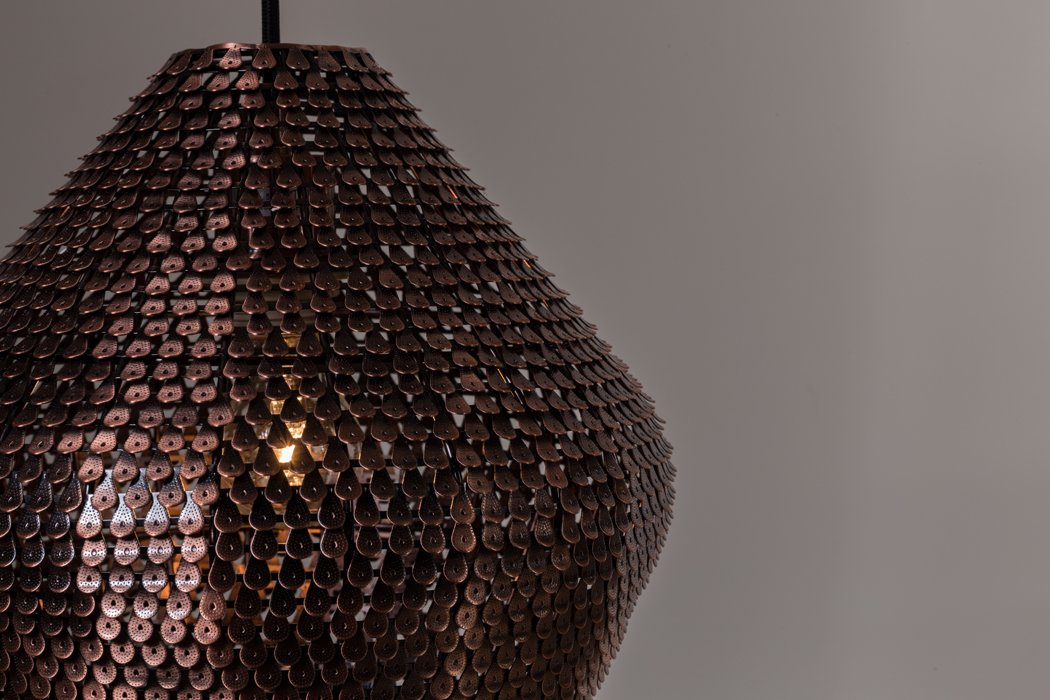 Shiny Cooper lamps were created from hundreds of small copper scales, which were additionally discolored at hot temperatures. Copper scales have been manually placed on the lamp, thanks to which each model has a unique shape and appearance. The lamp gives an amazing effect of light movement, bouncing off tiny copper tiles.
