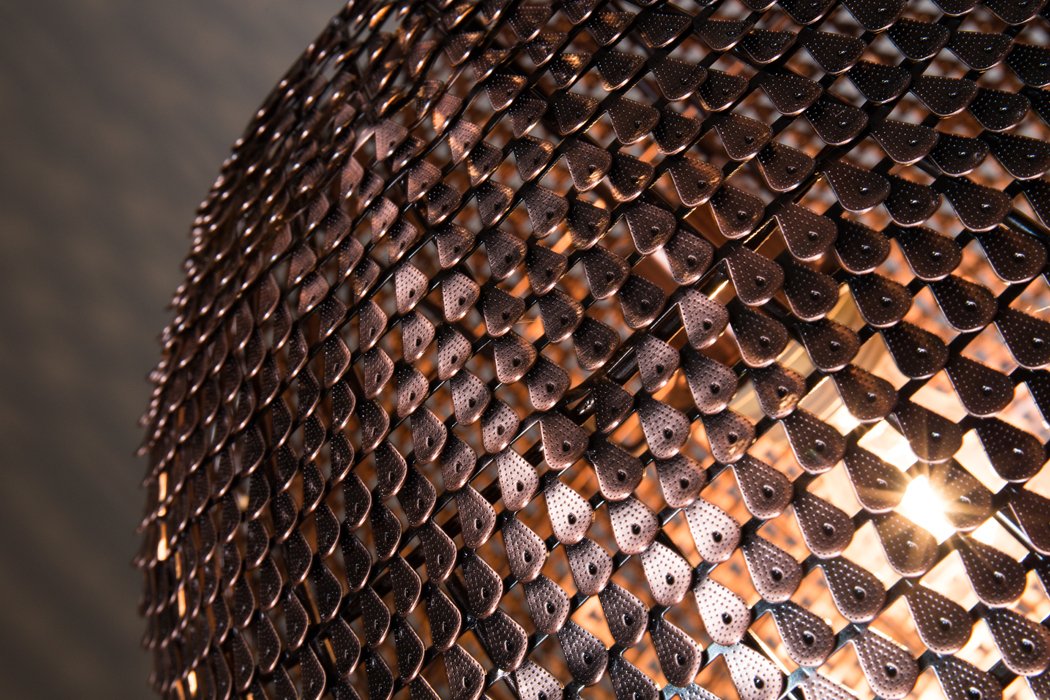 Shiny Cooper lamps were created from hundreds of small copper scales, which were additionally discolored at hot temperatures. Copper scales have been manually placed on the lamp, thanks to which each model has a unique shape and appearance. The lamp gives an amazing effect of light movement, bouncing off tiny copper tiles.
